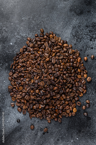 Roasted coffee beans on rustic table. Black background. Top view