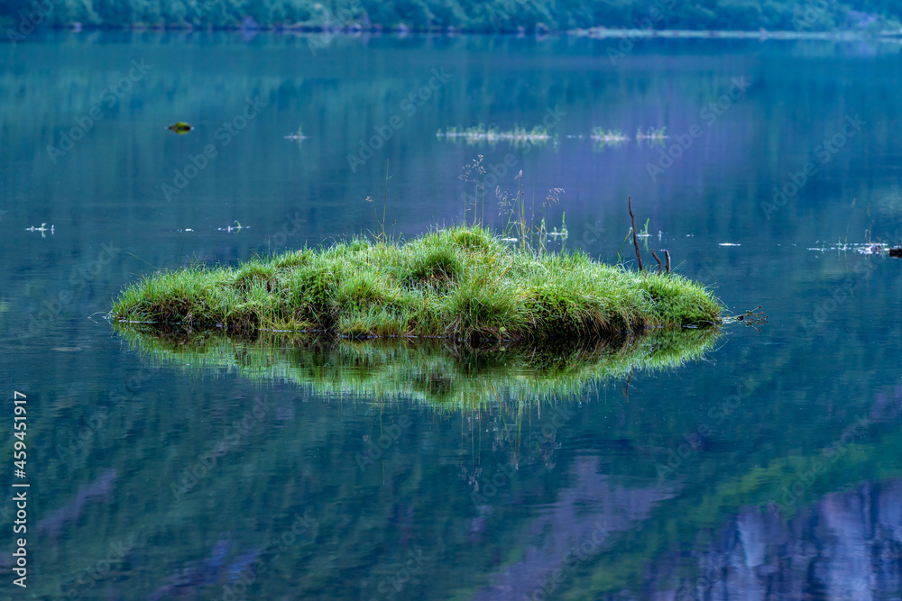 Tiny grass Island middle of the lake in the morning.