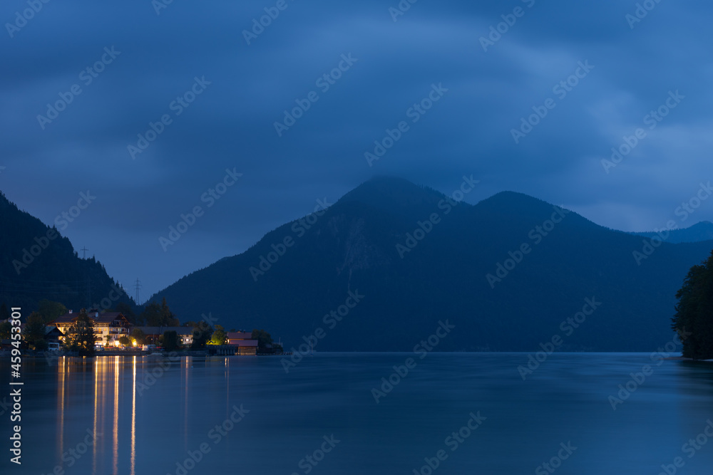The village Walchensee on the lake Walchensee at night with mountains in background