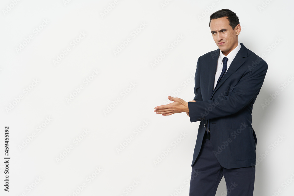 business man in a suit on a light background shows his hand to the side finance model manager business man in a suit on a light background shows his hand to the side finance model manager