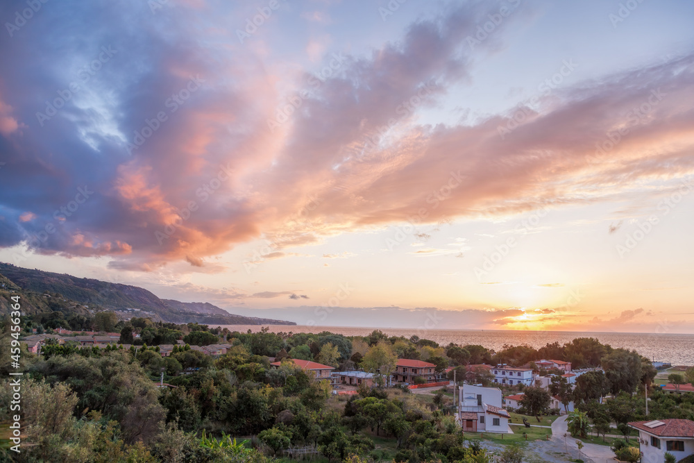 Obraz premium Sunset over Calabria coast with village next to the Tropea town in Vibo Valentia, Calabria, Southern Italy