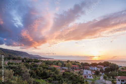 Sunset over Calabria coast with village next to the Tropea town in Vibo Valentia, Calabria, Southern Italy
