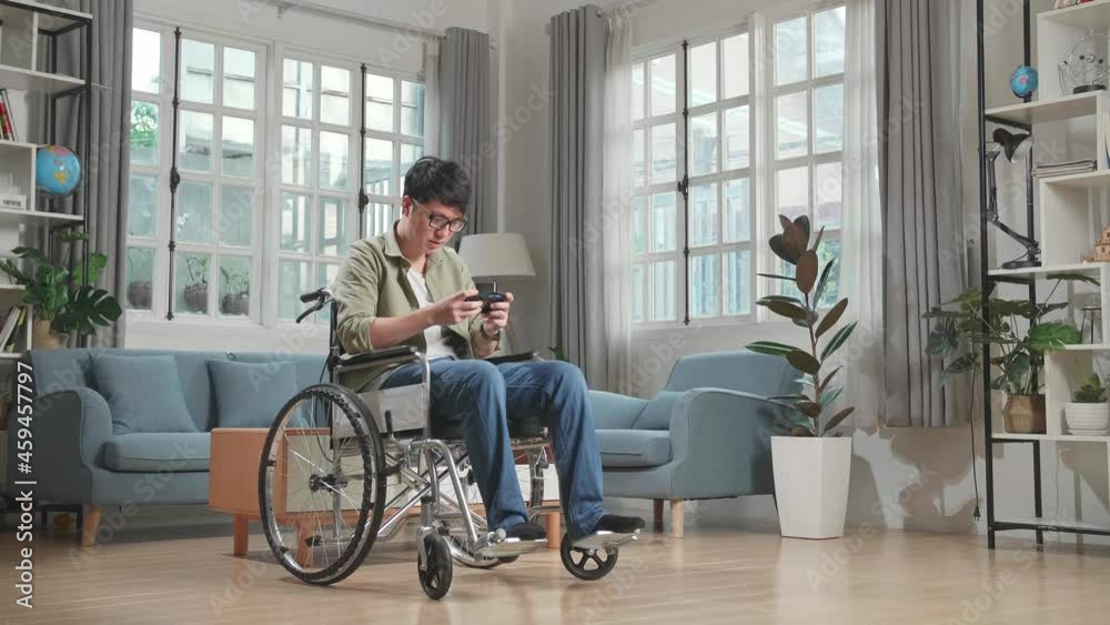 Asian Man Sitting In A Wheelchair While Use Mobile Phone Playing Video Game At Home
Asian Man Sitting In A Wheelchair While Use Mobile Phone Playing Video Game At Home