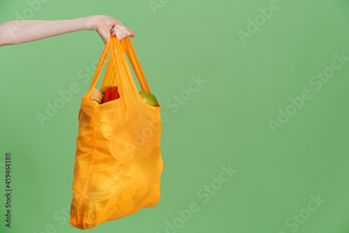 Photo of hand holding textile bag with vegetable