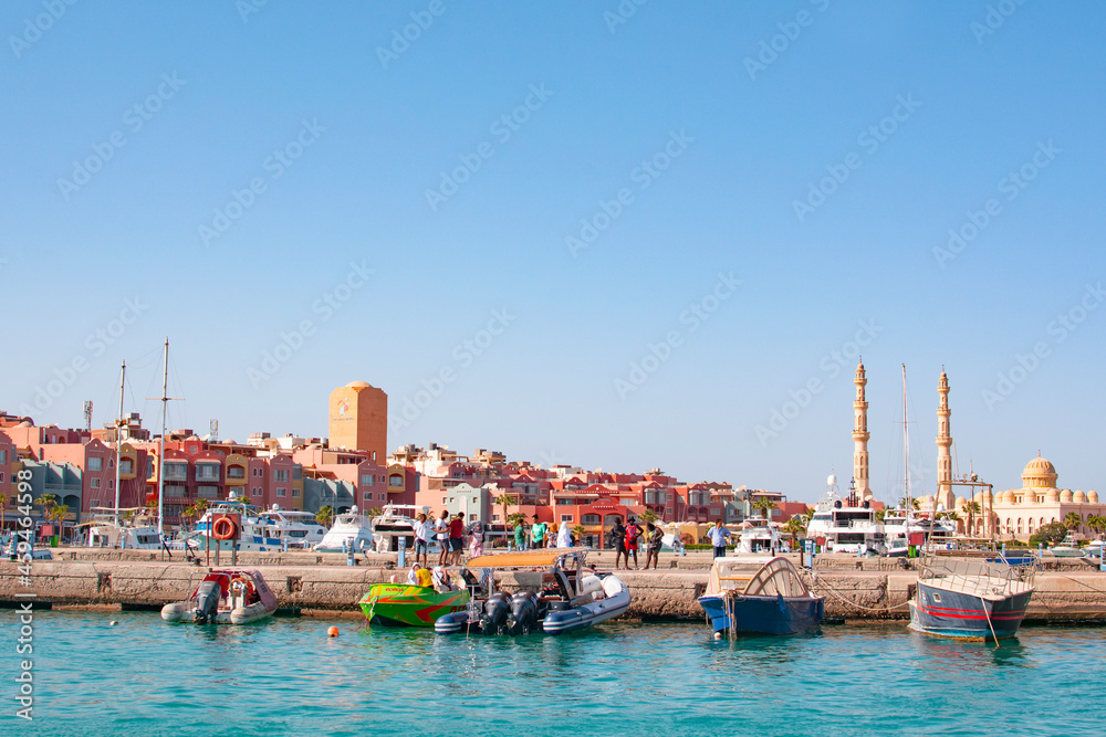 Obraz premium HURGHADA, EGYPT - September 22, 2021 : Mosque El Mina Masjid and the marina with the ships in Hurghada in sunny day, view from the sea.
