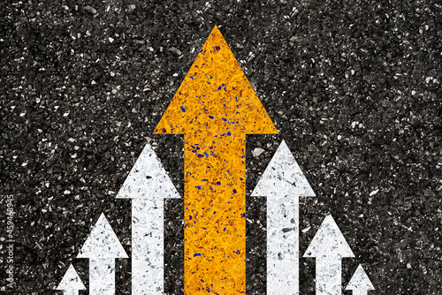 Fototapeta Naklejka Na Ścianę i Meble -  Yellow big arrow move leading from small white arrow on road asphalt for leadership concept.