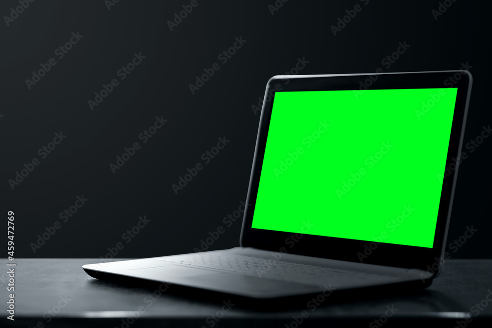 Fototapeta premium Creative background dark laptop stands on a dark background. Modern technology concept.