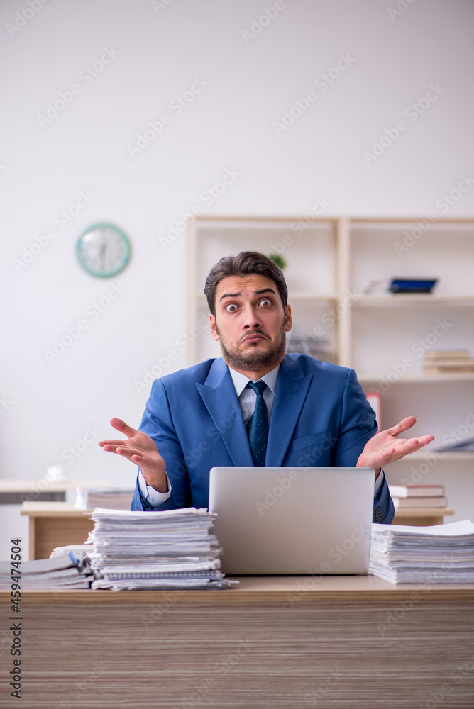 Young businessman employee and too much work in the office Young businessman employee and too much work in the office