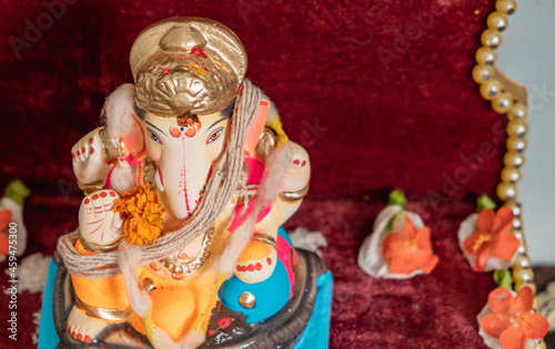 Idol of Lord Ganesh of a shadu clay a Hindu Religion God on the occasion of 'ganesh chaturthi' in India with flowers and decoration.