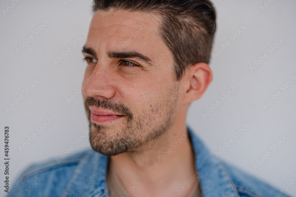 Fototapeta premium Portrait of young caucasian man on white background, looking aside.