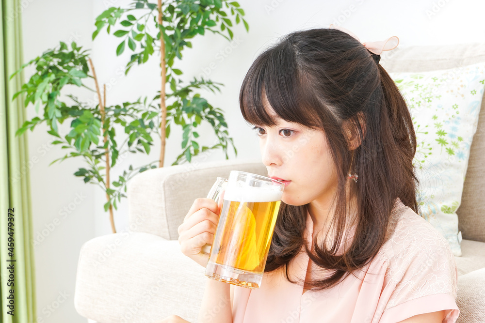 自宅でビールを飲む若い女性 自宅でビールを飲む若い女性