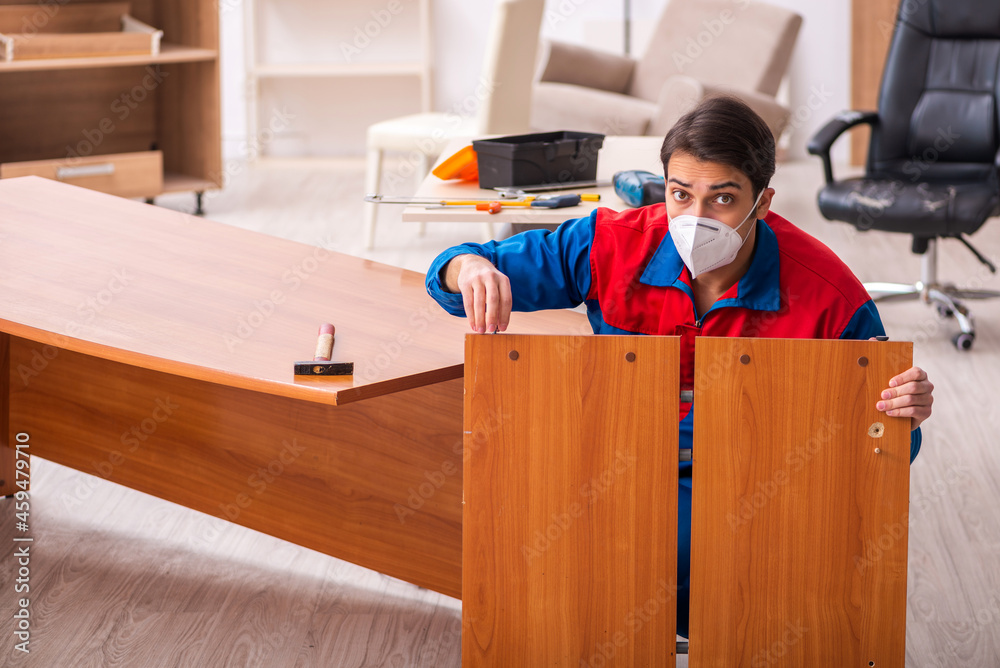 Young male carpenter working in the office during pandemic Young male carpenter working in the office during pandemic