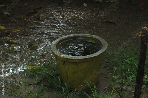 Empty rusted or dust old flower pot filled with rain water in the rain