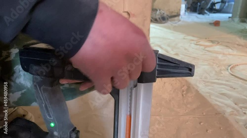Worker loading gun nailer closeup construction site electrician  photo