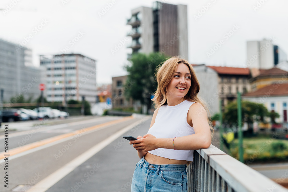 Young caucasian woman using smartphone looking camera positive and trustful in future
