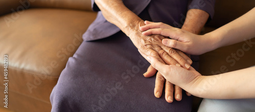 Caregiver and eldery woman holding hands. Support of nursing family caregiver. Senior services and geriatric care concept. photo