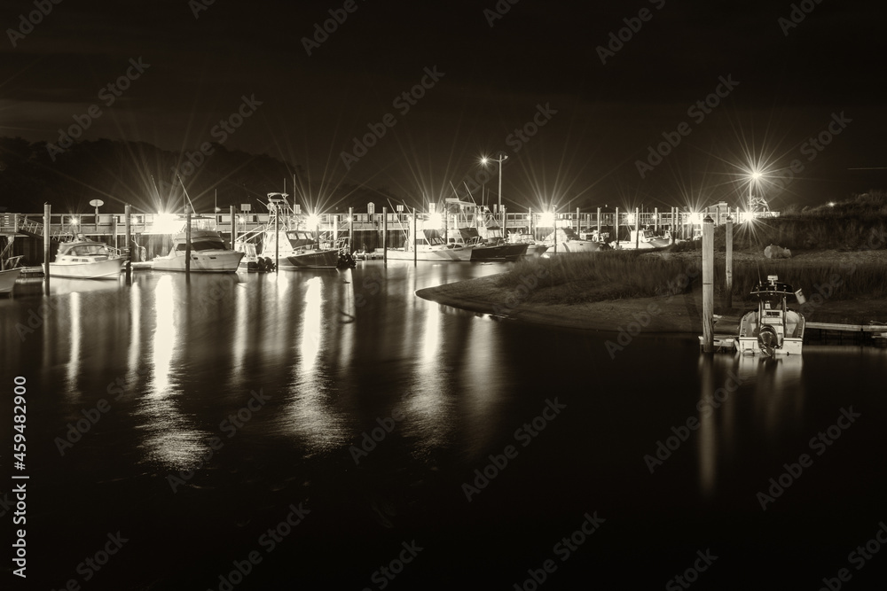 Harbor with ships and lights taken at night in black and white