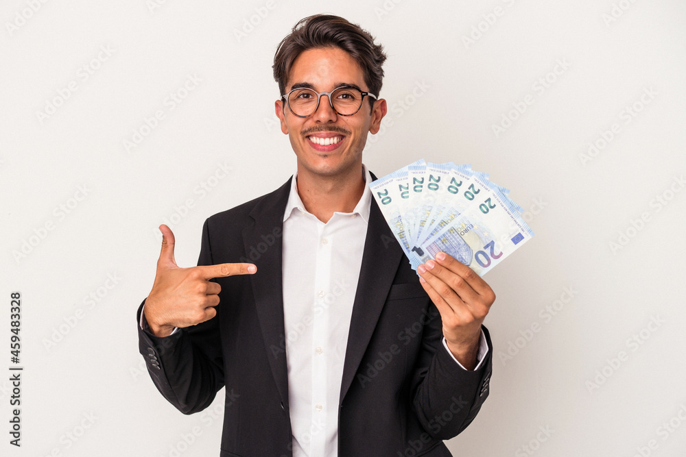 Young mixed race business man holding bills isolated on white background person pointing by hand to a shirt copy space, proud and confident Young mixed race business man holding bills isolated on white background person pointing by hand to a shirt copy space, proud and confident