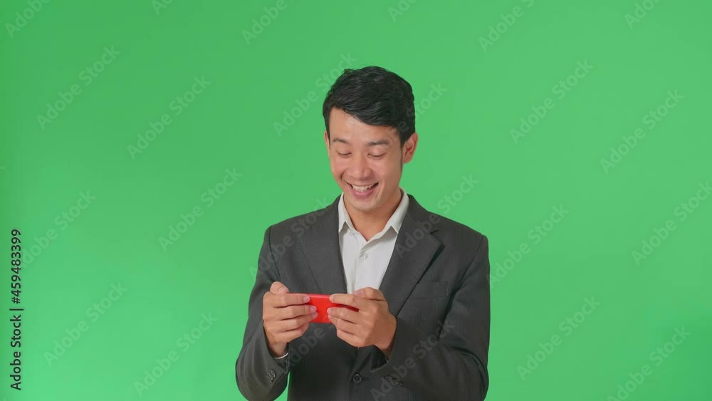 Laughing Asian Business Man Looking At The Phone Screen And Holding It In Her Hands While Standing On Green Screen In The Studio
Laughing Asian Business Man Looking At The Phone Screen And Holding It In Her Hands While Standing On Green Screen In The Studio