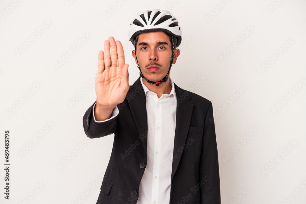 Young mixed race business man wearing a bike helmet isolated on white background standing with outstretched hand showing stop sign, preventing you. Young mixed race business man wearing a bike helmet isolated on white background standing with outstretched hand showing stop sign, preventing you.