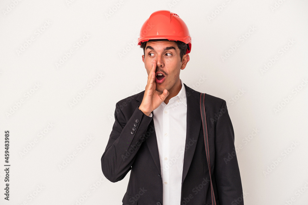 Young architect mixed race man isolated on white background is saying a secret hot braking news and looking aside Young architect mixed race man isolated on white background is saying a secret hot braking news and looking aside