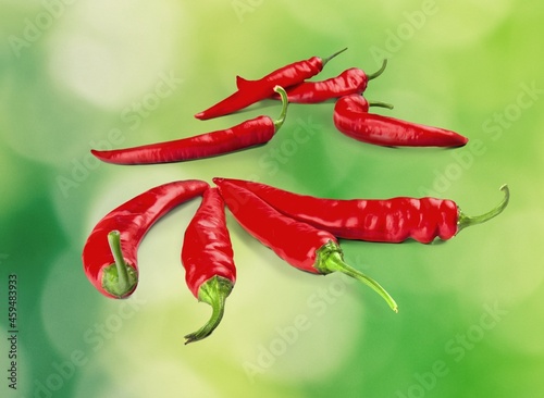 Fresh spicy red chilli peppers with seeds floating in the air.