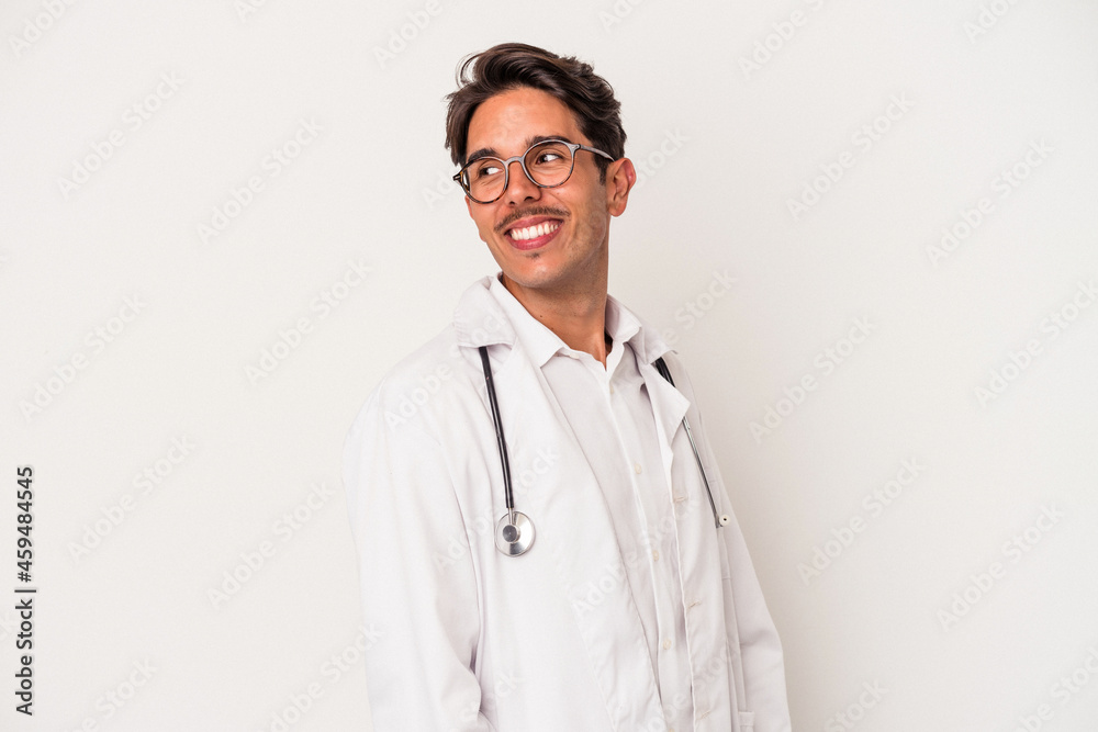 Young mixed race doctor man isolated on white background looks aside smiling, cheerful and pleasant. Young mixed race doctor man isolated on white background looks aside smiling, cheerful and pleasant.