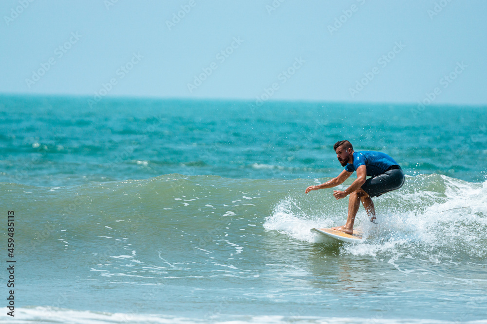 Mężczyzna surfer płynący na fali na tle błękitnego oceanu i nieba. Mężczyzna surfer płynący na fali na tle błękitnego oceanu i nieba.