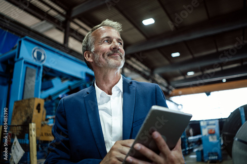 Senior businessman holding digital tablet at metal industry photo