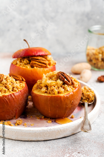 Baked Apples Stuffed with pecans, cinnamon, streyzel and honey on old concrete light background. Rustic stale