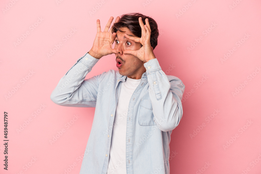 Young mixed race man isolated on white background keeping eyes opened to find a success opportunity. Young mixed race man isolated on white background keeping eyes opened to find a success opportunity.