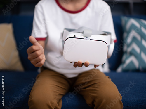 the boy with virtual reality headset is stunned by VR experience. Teen wearing vr glasses to you.