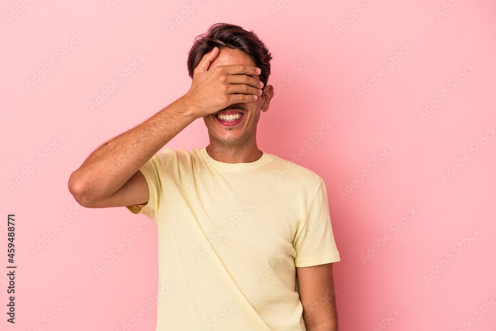 Young mixed race man isolated on white background covers eyes with hands, smiles broadly waiting for a surprise. Young mixed race man isolated on white background covers eyes with hands, smiles broadly waiting for a surprise.