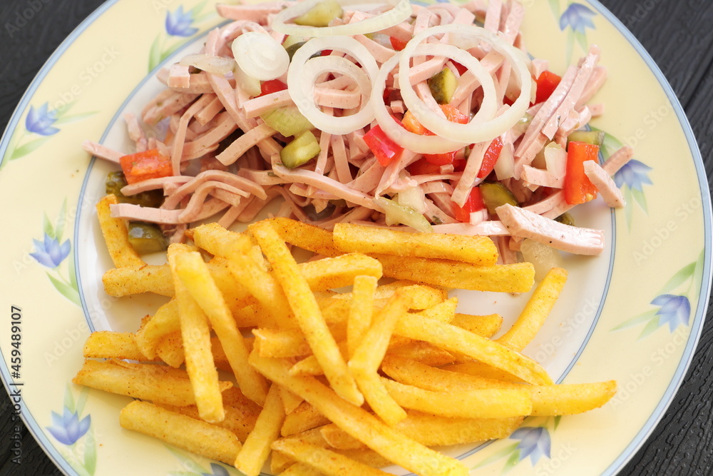 a plate of fresh sausage salad and french fries 