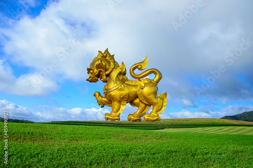 Singha or Lion golden statue on blue sky background in chiang rai thailand.