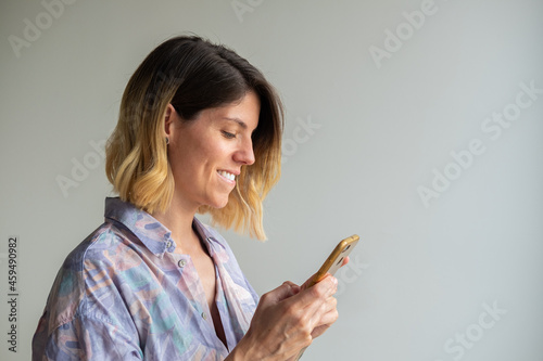 Beautiful smile and white teeth of a young blonde woman with mobile phone