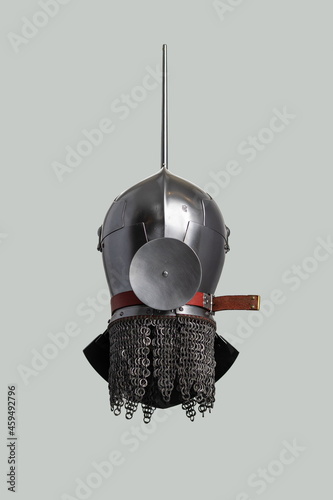 Medieval knightly Milanese helmet with a heraldic kleinod in the form of a swan and a crown, period of the 15th century, on a light background. photo