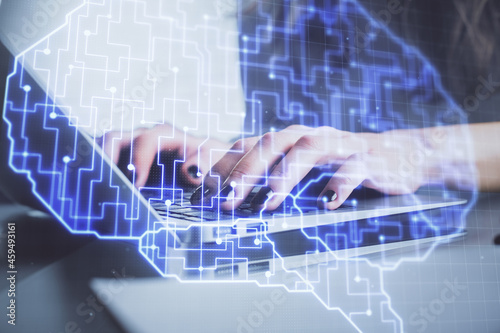 Double exposure of woman hands working on computer and brain hologram drawing. Ai concept.