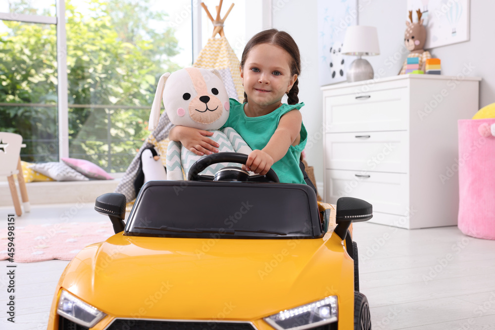 Adorable child with toy driving car in room at home Adorable child with toy driving car in room at home