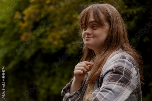 Portrait of young woman with Down Syndrome looking surprised outdoors