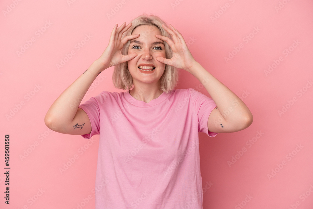 Young caucasian woman isolated on pink background keeping eyes opened to find a success opportunity. Young caucasian woman isolated on pink background keeping eyes opened to find a success opportunity.