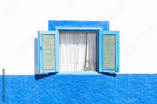 Fototapeta Naklejka Na Ścianę i Meble -  window open in a white an blue house in a sunny day