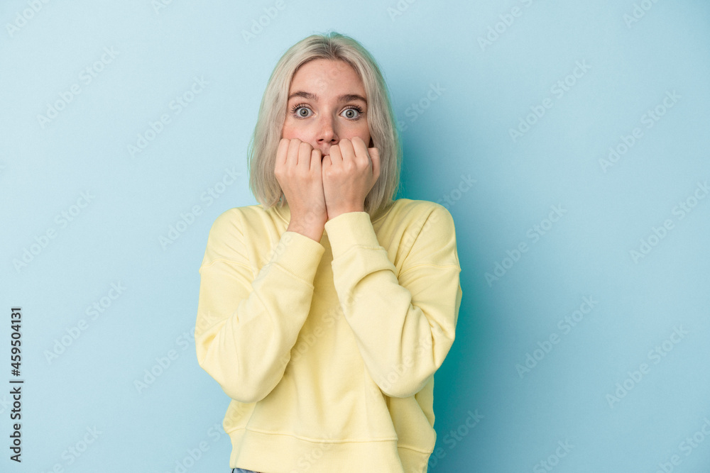 Young caucasian woman isolated on blue background biting fingernails, nervous and very anxious. Young caucasian woman isolated on blue background biting fingernails, nervous and very anxious.