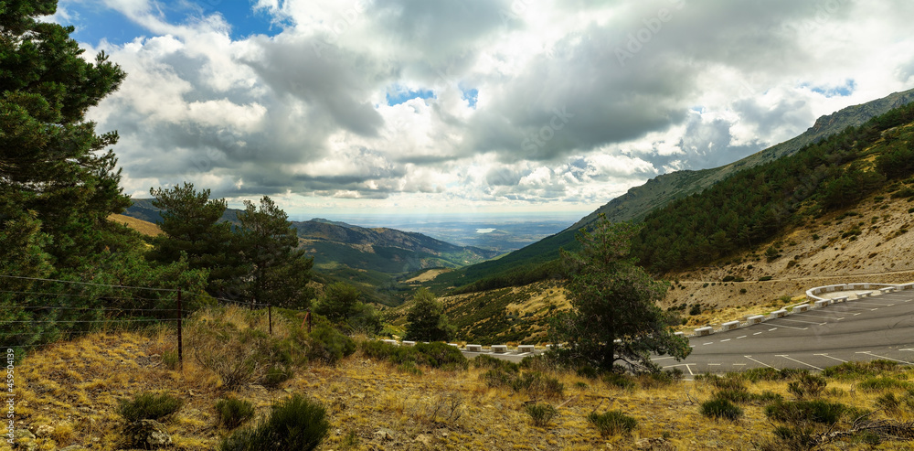 Panoramic green mountain landscape with the valley and the lake in the background of the image.