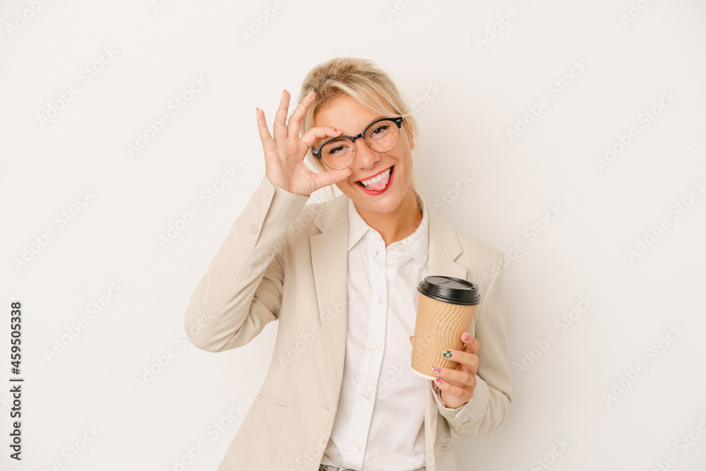 Young business Russian woman holding take away coffee isolated on white background excited keeping ok gesture on eye.