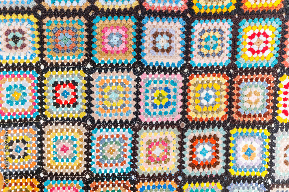 A bright Blanket with an ornament in the form of colorful squares woven from wool. The concept of fabric and national patterns