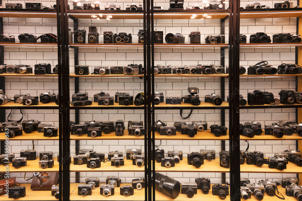 Many retro different film photo cameras on rack