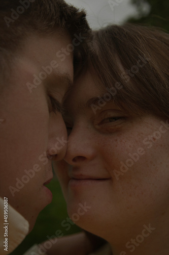Face to face portrait of young couple with Down Syndrome and Foetal Alcohol Syndrome looking confident and touching noses