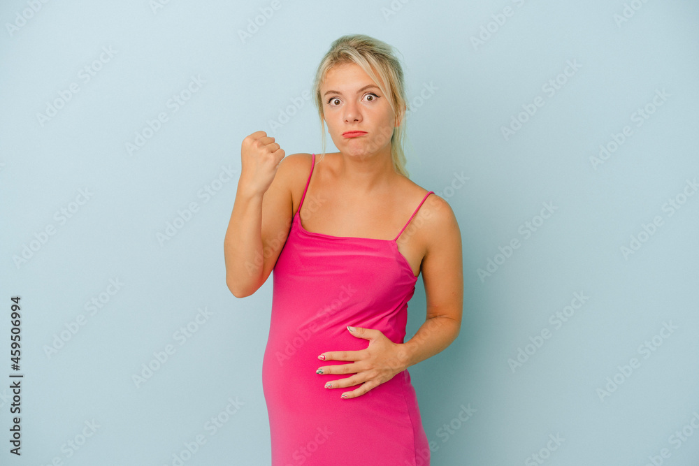 Young Russian woman pregnant isolated on blue background showing fist to camera, aggressive facial expression. Young Russian woman pregnant isolated on blue background showing fist to camera, aggressive facial expression.