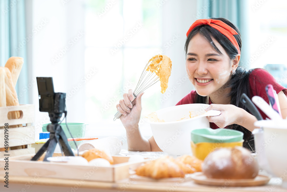 close up woman blogger making a bread, whisking cream in a bowl and recording stream live video online from camera close up woman blogger making a bread, whisking cream in a bowl and recording stream live video online from camera